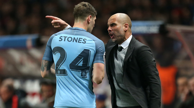 Manchester City manager Pep Guardiola (right) gives instructions to Manchester City's John Stones from the touchline