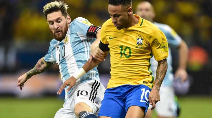 Lionel Messi battles Neymar for the ball