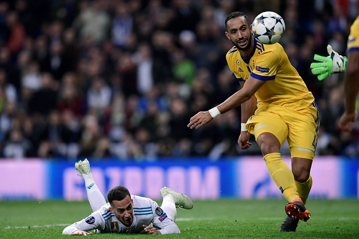 Medhi Benatia of Juventus brings down Lucas Vasquez of Real Madrid.