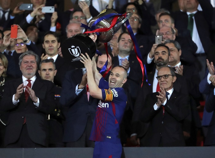 FC Barcelona's midfielder Andres Iniesta raises the Copa Del Rey trophy.