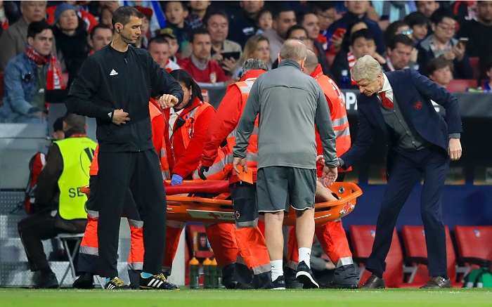 Arsenal manager Arsene Wenger speaks with Arsenal's Laurent Koscielny as he is stretchered off.