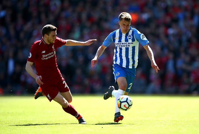 Brighton & Hove Albion's Solly March and Liverpool's Andrew Robertson battle for the ball.