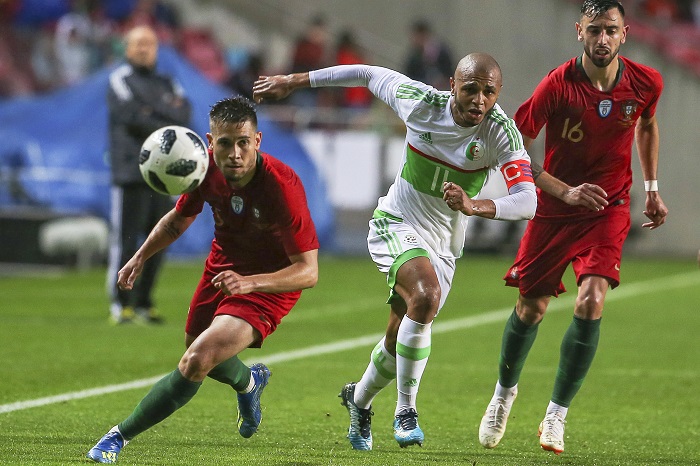 Algeria's Yacine Brahimi in action against Portugal players Raphael Guerreiro and Bruno Fernandes.