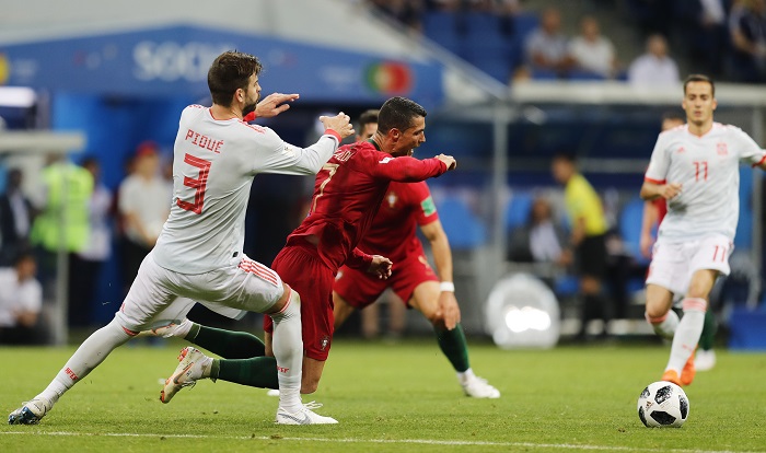 Gerard Pique of Spain fouls Cristiano Ronaldo of Portugal.