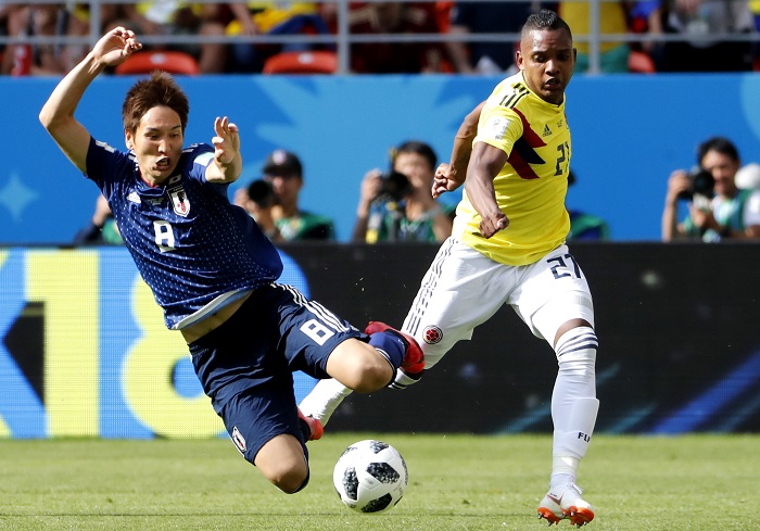 Genki Haraguchi (of Japan and Jose Izquierdo of Colombia battle for the ball.