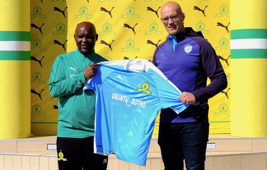 Mamelodi Sundowns coach Pitso Mosimane hands the new kit to Bulls coach John Mitchell