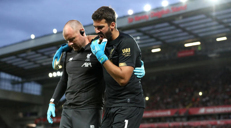 Liverpool goalkeeper Alisson leaves the pitch after picking up an injury d