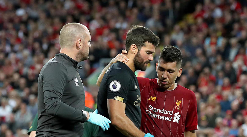 Liverpool goalkeeper Alisson is consoled by team-mate Roberto Firmino after picking up an injury during the Premier League match at Anfield, Liverpool.