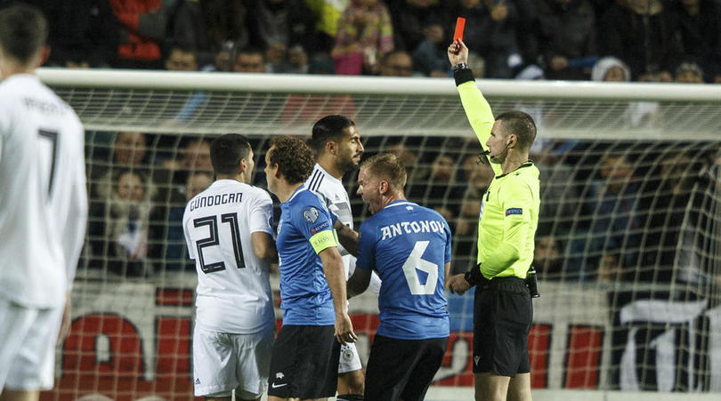 Referee Georgi Kabakov shows a red card to Germany's Emre Can, centre, for foul to Estonia's Frank Liivak during the Euro 2020 group C qualifying soccer match between Estonia and Germany at the A. Le Coq Arena in Tallinn, Estonia, Sunday, Oct. 13, 2019. (AP Photo/Raul Mee)