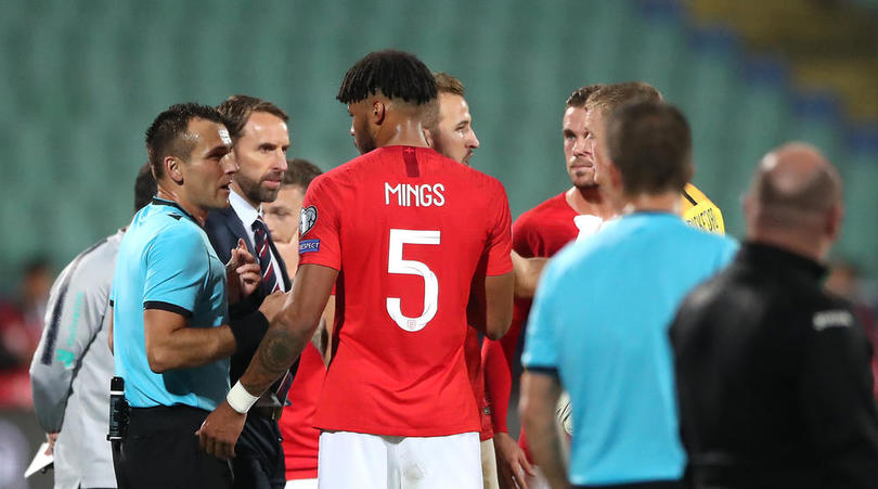 Match referee Ivan Bebek speaks to England manager Gareth Southgate and Tyrone Mings with regards to racist chanting from fans