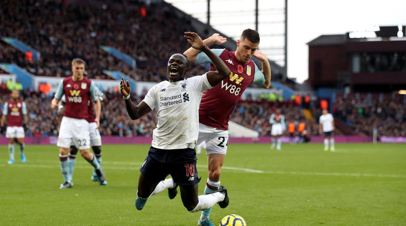 Liverpool's Sadio Mane goes down in the area under the challenge from Aston Villa's Frederic Guilbert and is booked for diving during the Premier League match at Villa Park, Birmingham.