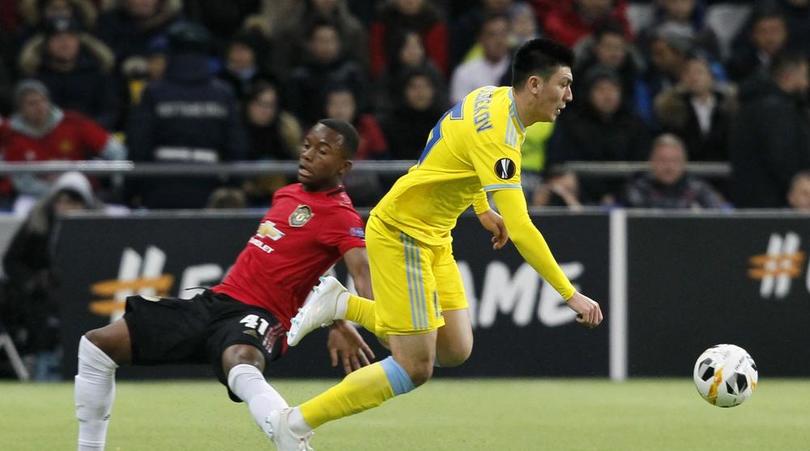 Manchester United's Ethan Laird, left, and Astana's Abzal Beisebekov challenge for the ball during the Europa League Group L soccer match between Astana and Manchester United in Astana, Kazakhstan, Thursday, Nov. 28, 2019. (AP Photo/Stas Filippov)