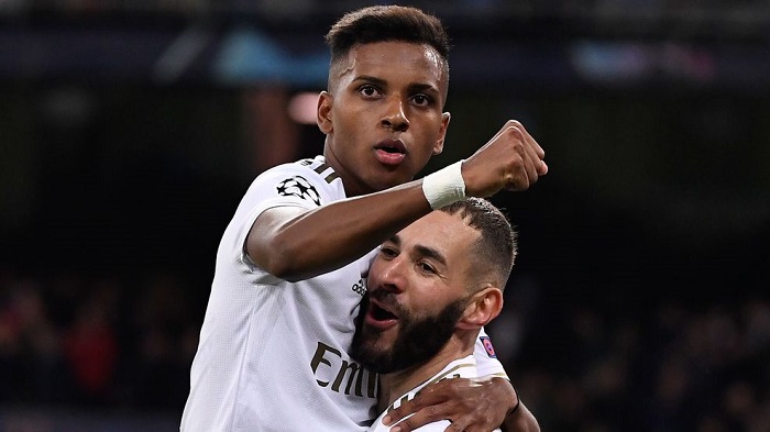 Real Madrid's French forward Karim Benzema celebrates with teammate Rodrygo