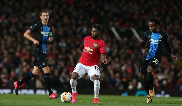 Club Brugge's Percy Tau chases down Manchester United midfielder Fred